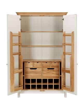 A white wooden larder unit with door open to reveal a series of shelves and drawers.