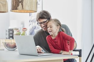 Father and daughter learning from home with free broadband during lockdown