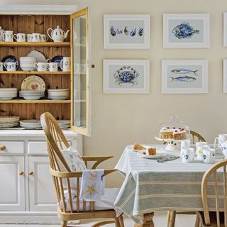 country kitchen dining area with a glass fronted dresser and artwork on the wall