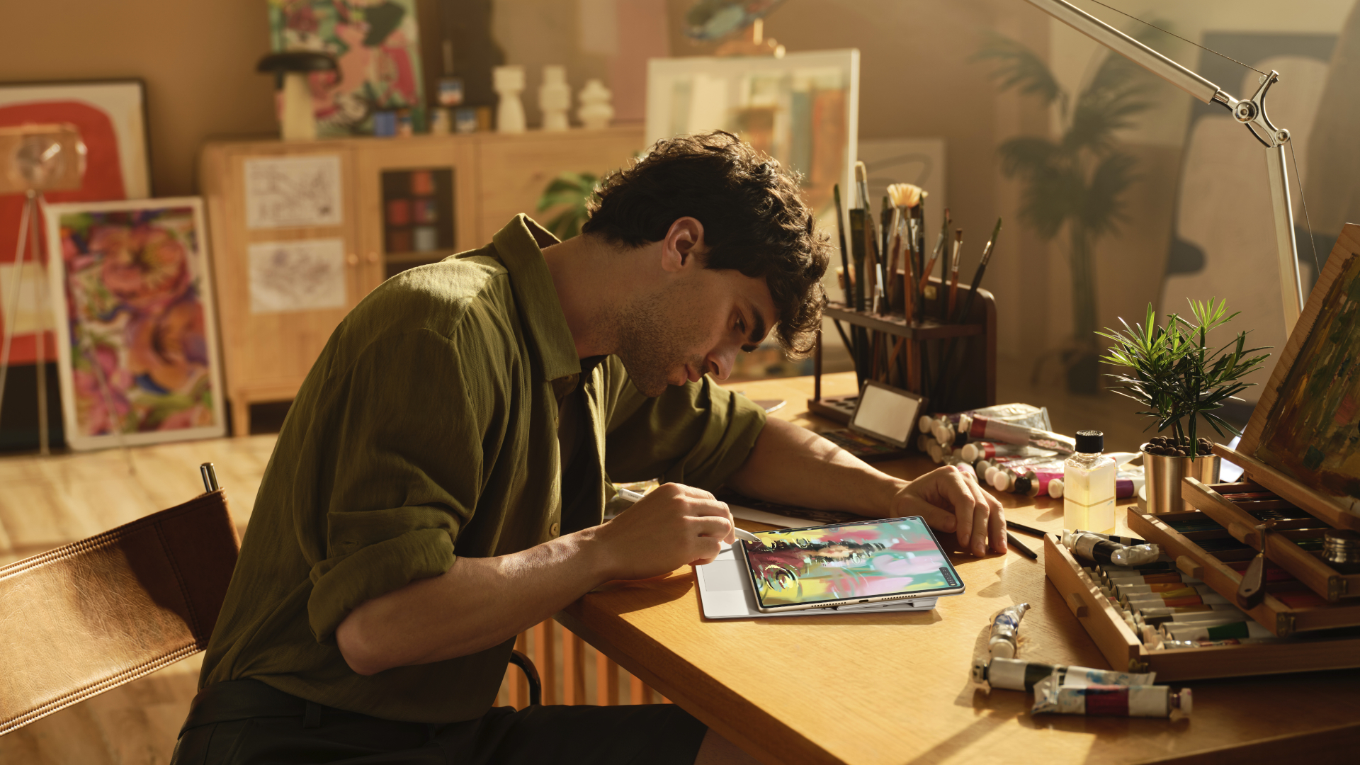 A man leans over the Huawei MatePad Pro 12.2 to draw on it with the M-Pencil stylus