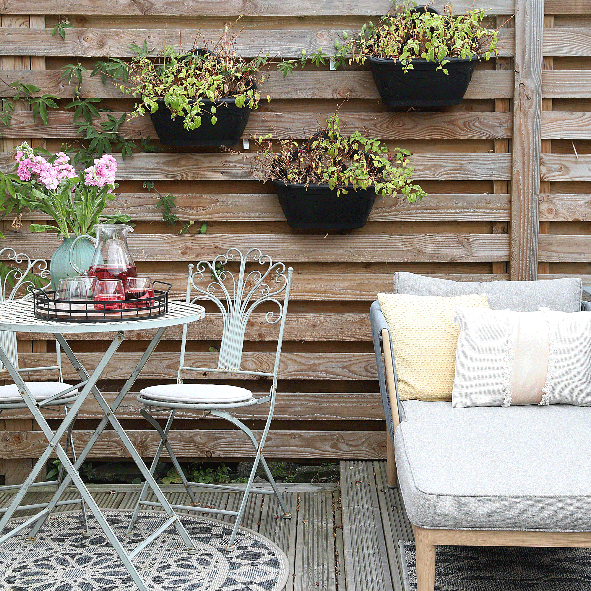 Green bistro set with planters hung on fence