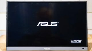 ASUS ZenScreen MQ16AH portable monitor standing on wooden desk
