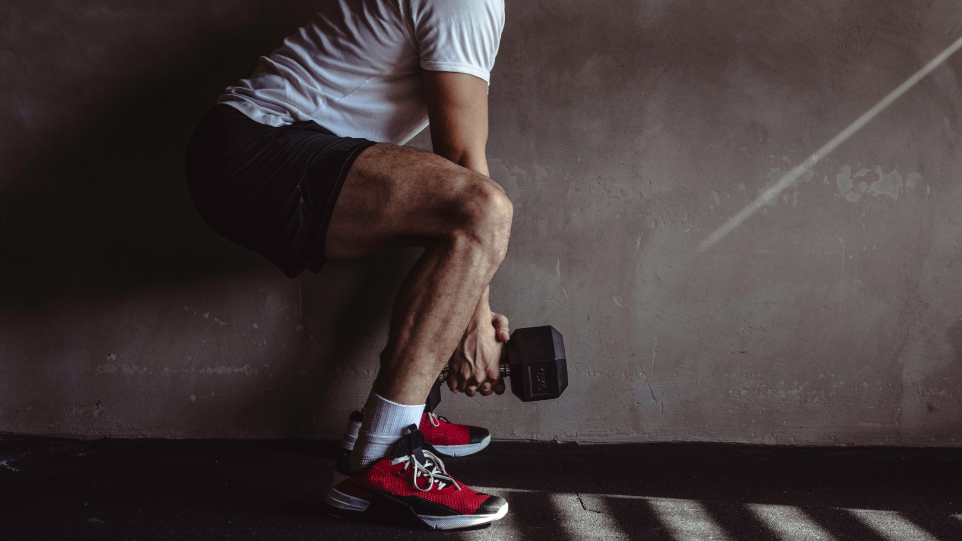 A man performing a dumbbell squat
