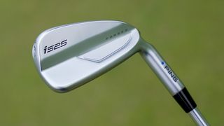 Ping i525 Iron Review held aloft on the course showing its chrome back