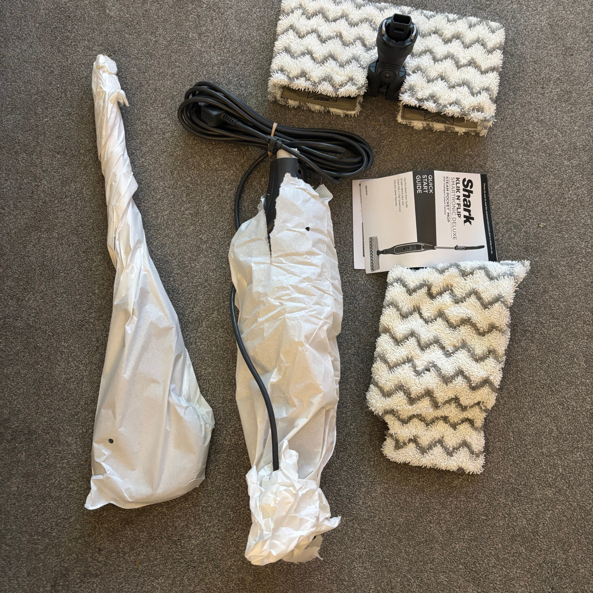 flatlay of Shark Klik n’ Flip Automatic Steam Mop parts and accessories