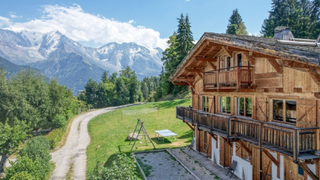 A large wooden ski chalet with balconies along the exterior