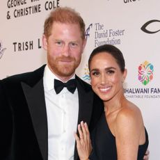 Meghan Markle wears a long black dress with Princess Diana's butterfly earrings