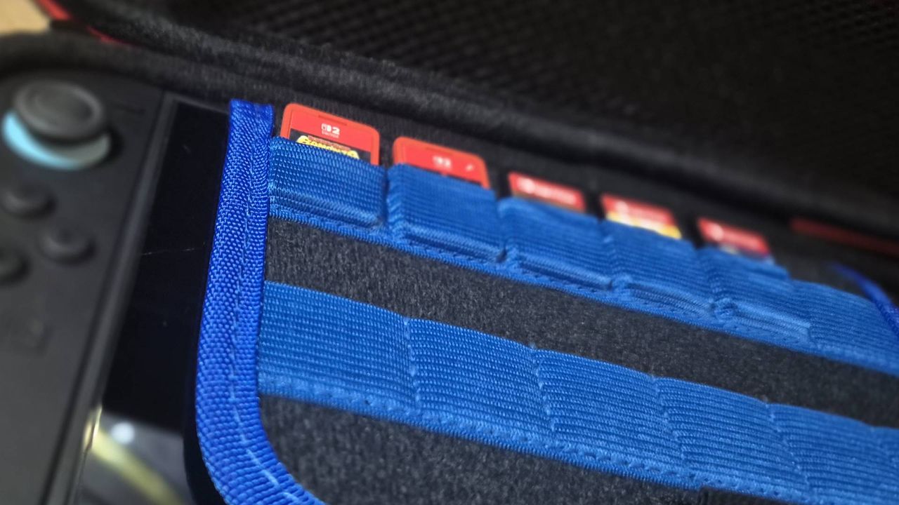 Photo of the inside of a Switch 2 case, showing Switch and Switch 2 games stored in blue fabric pockets.