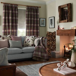 Living room with fireplace, sofa and tartan curtains