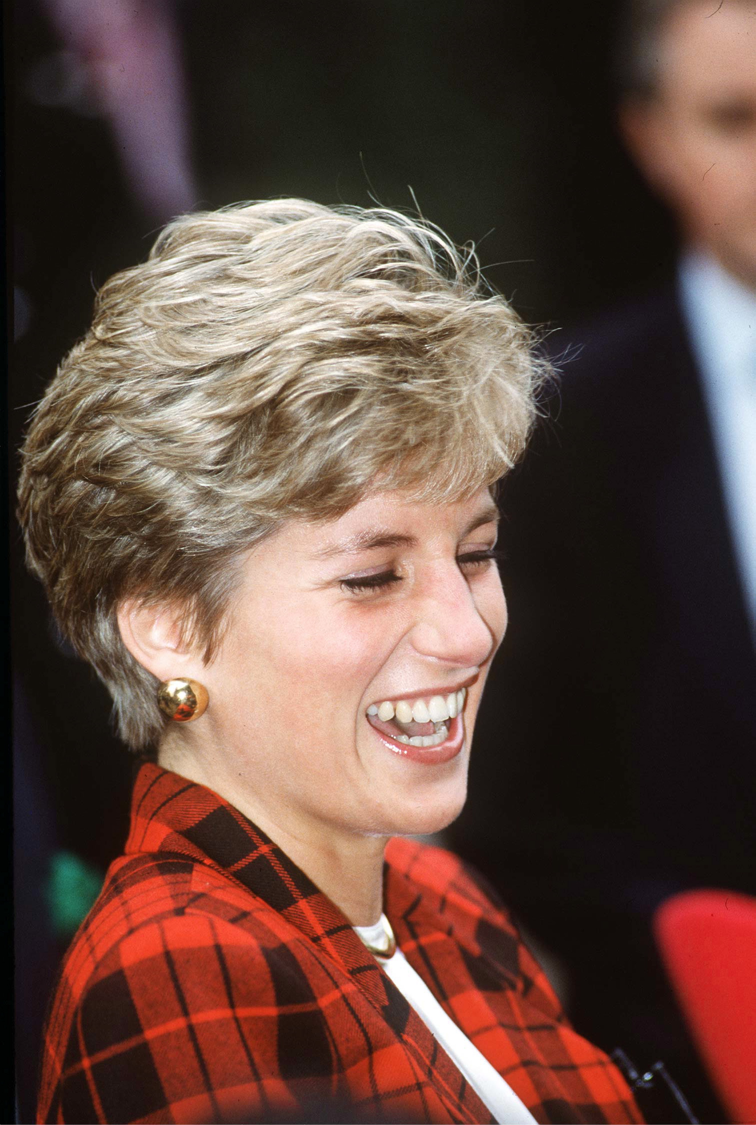 Princess Diana wearing a red plaid suit and laughing