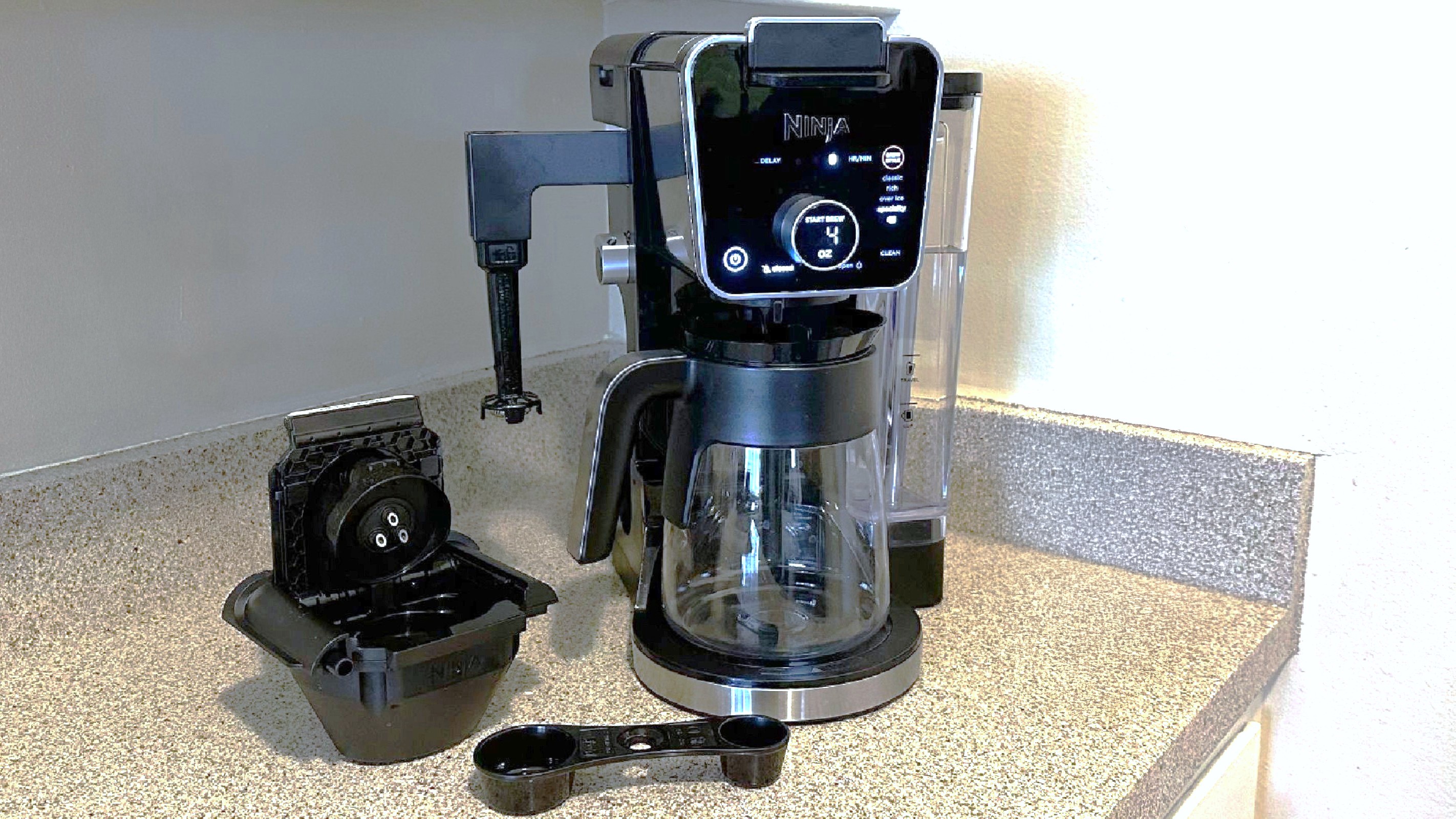 Ninja Dualbrew Pro coffee maker, coffee scoop and K-Cup adapter on kitchen counter