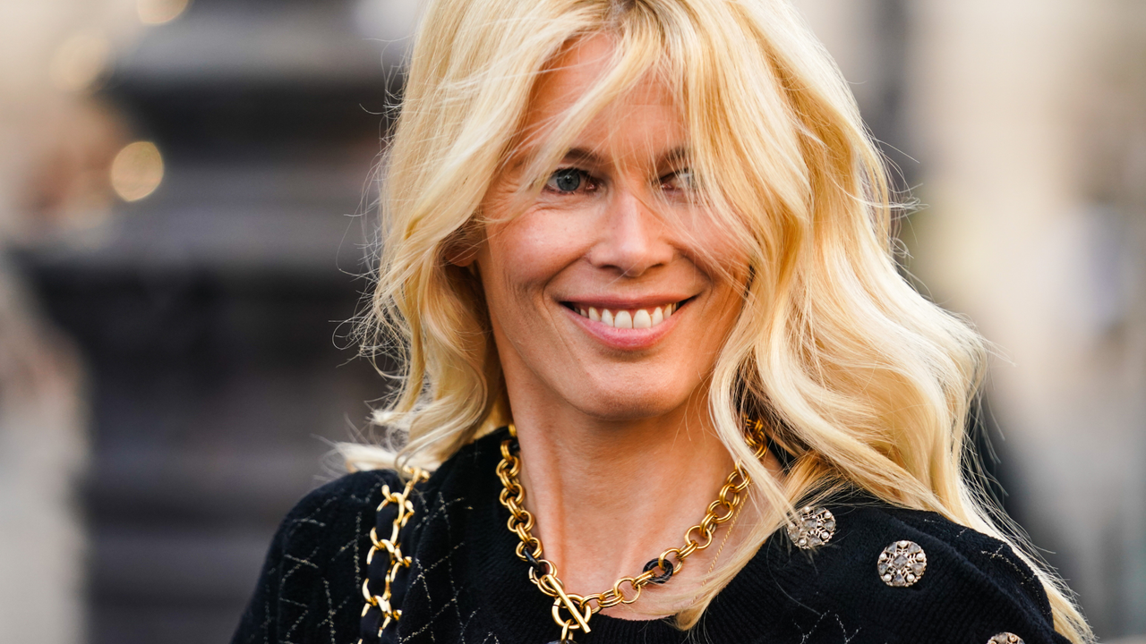 Hair Colours For Over 50sClaudia Schiffer wearing a black jacket smiling, with the wind in her blonde hair demonstrating hair colours for the over 50s