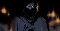 Garrett, stood face-on wearing a hood and cowl, stares menacingly out of the picture.