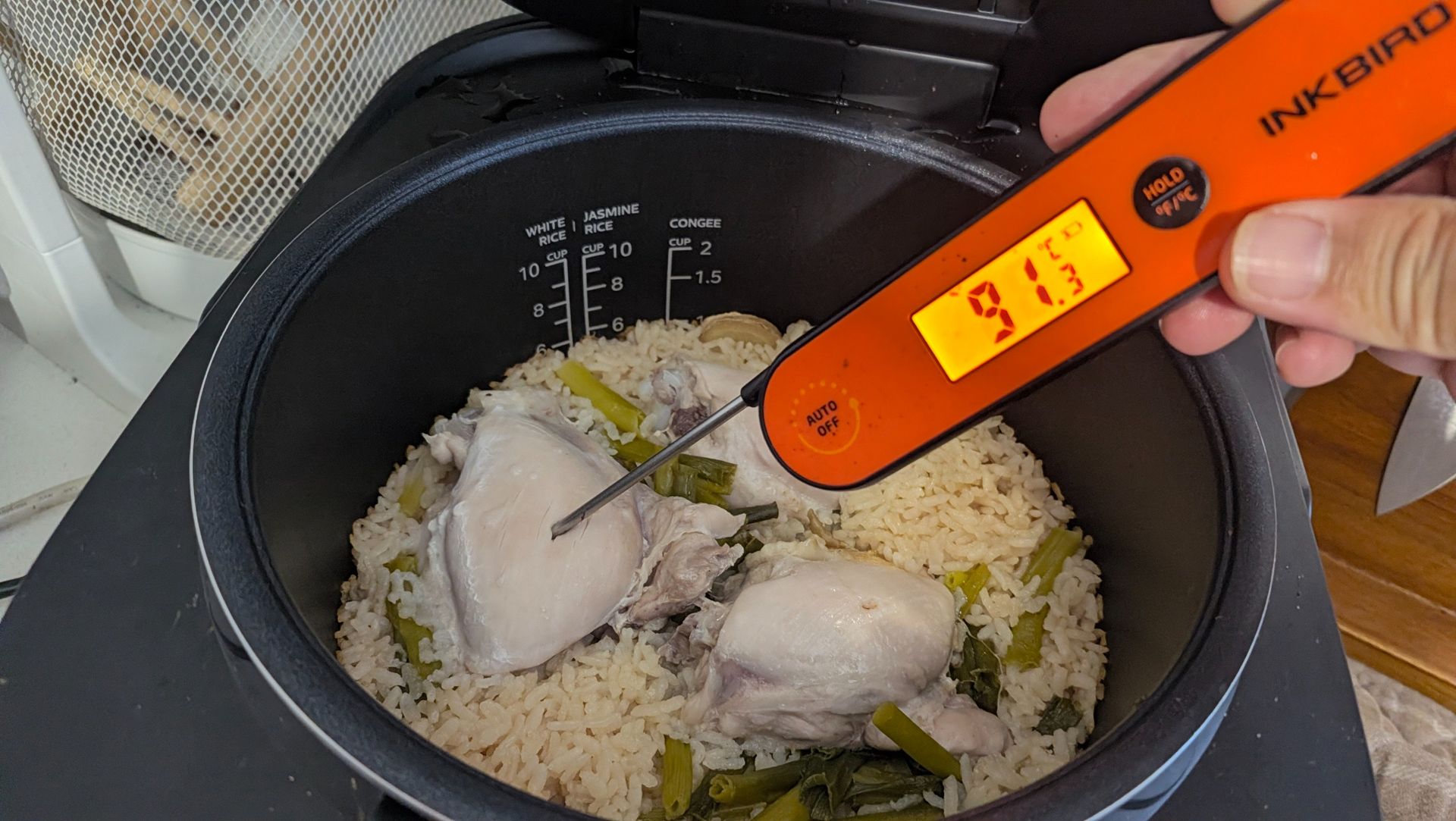 Midea 5L Induction Rice Cooker with a chicken and rice dish with a thermometer checking for doneness