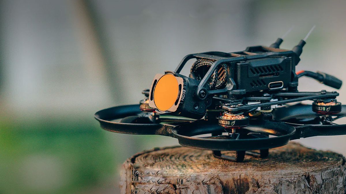 BetaFPV drone with DJI O3 sitting on a tree stump