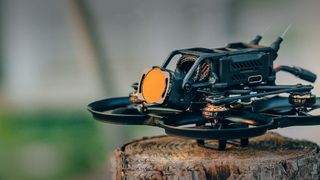 BetaFPV drone with DJI O3 sitting on a tree stump