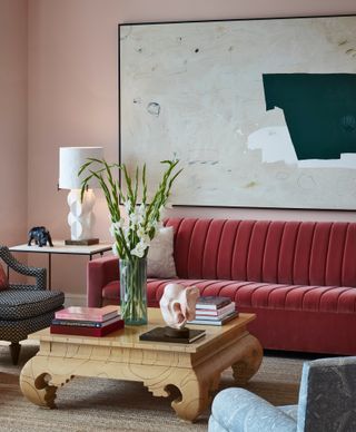 Pink living room with large artwork and red sofa