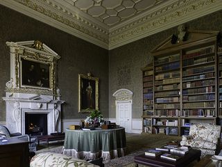 Crichel, Dorset: The library, with its gargantuan bookcases designed by Humphrey Sturt after 1765. The fine fireplace, with its copy of Van Dyke’s portrait of the Earl of Strafford and his secretary, is probably recycled from another 1740s building