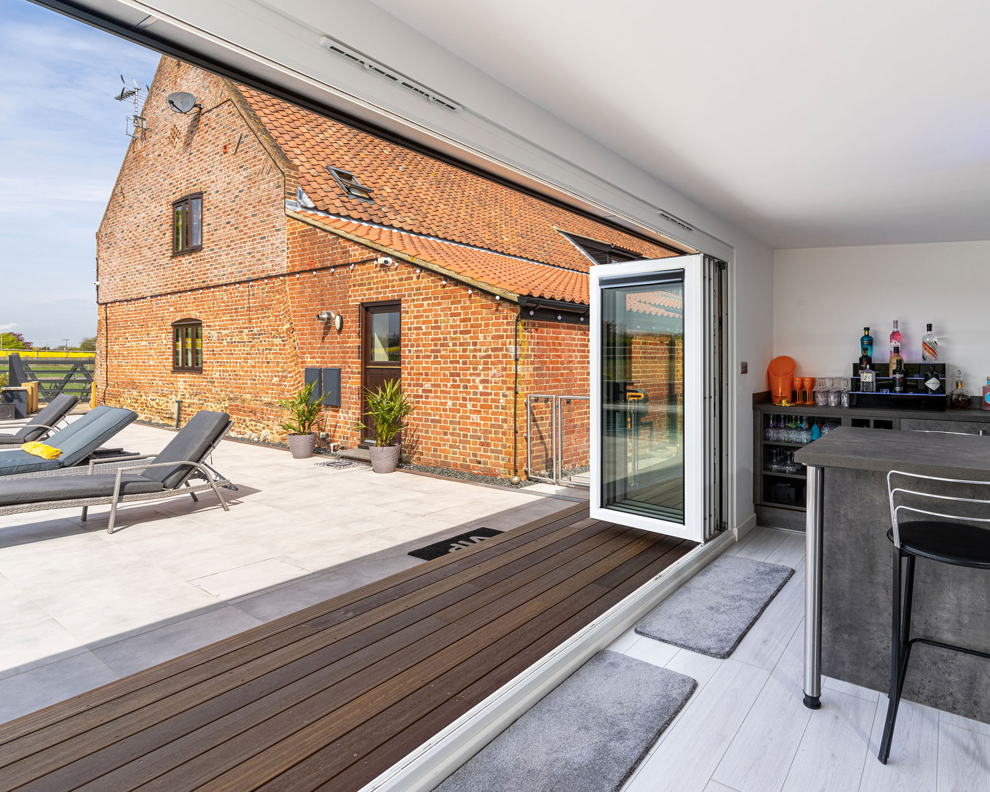 Garden room with accent decking and bifold sliding doors with reclined deck chairs