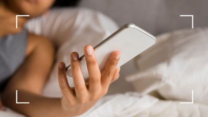 Woman looking at phone in bed