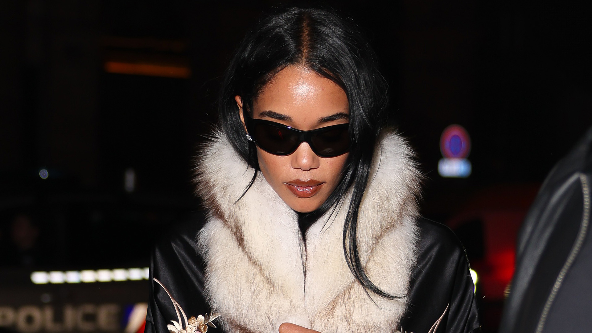 Laura Harrier at PFW wearing a Conner Ives embroidered fur robe with capri pants and pumps