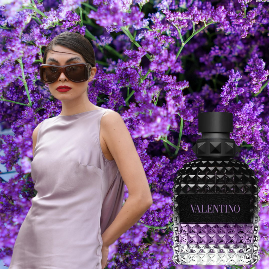 A woman wearing a lavender halter-neck top beside a bottles of lavender-colored perfume. 