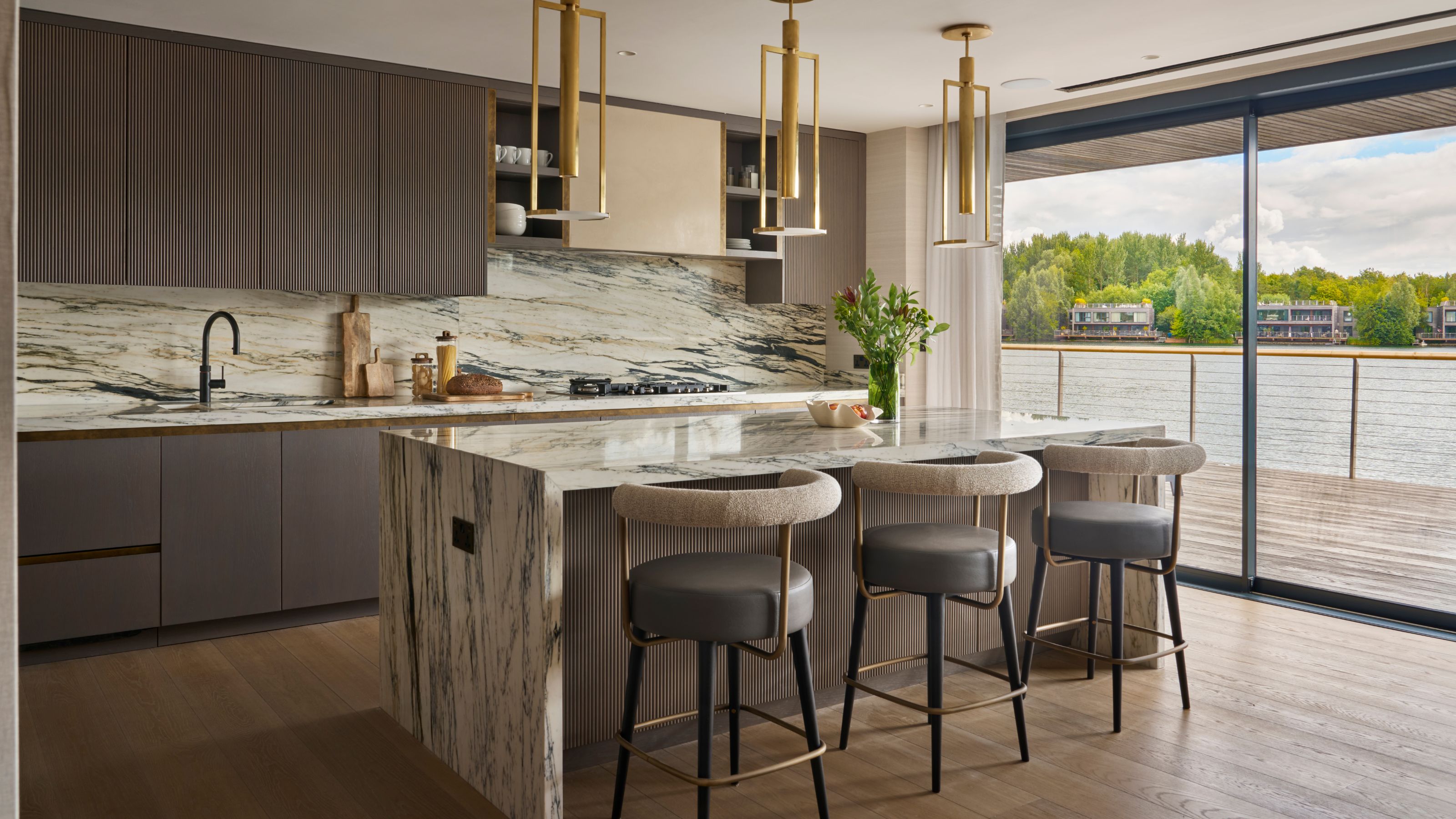 luxury kitchen with large marble island and taupe handless cabinets