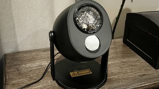 Govee's star light projector standing on electric fireplace