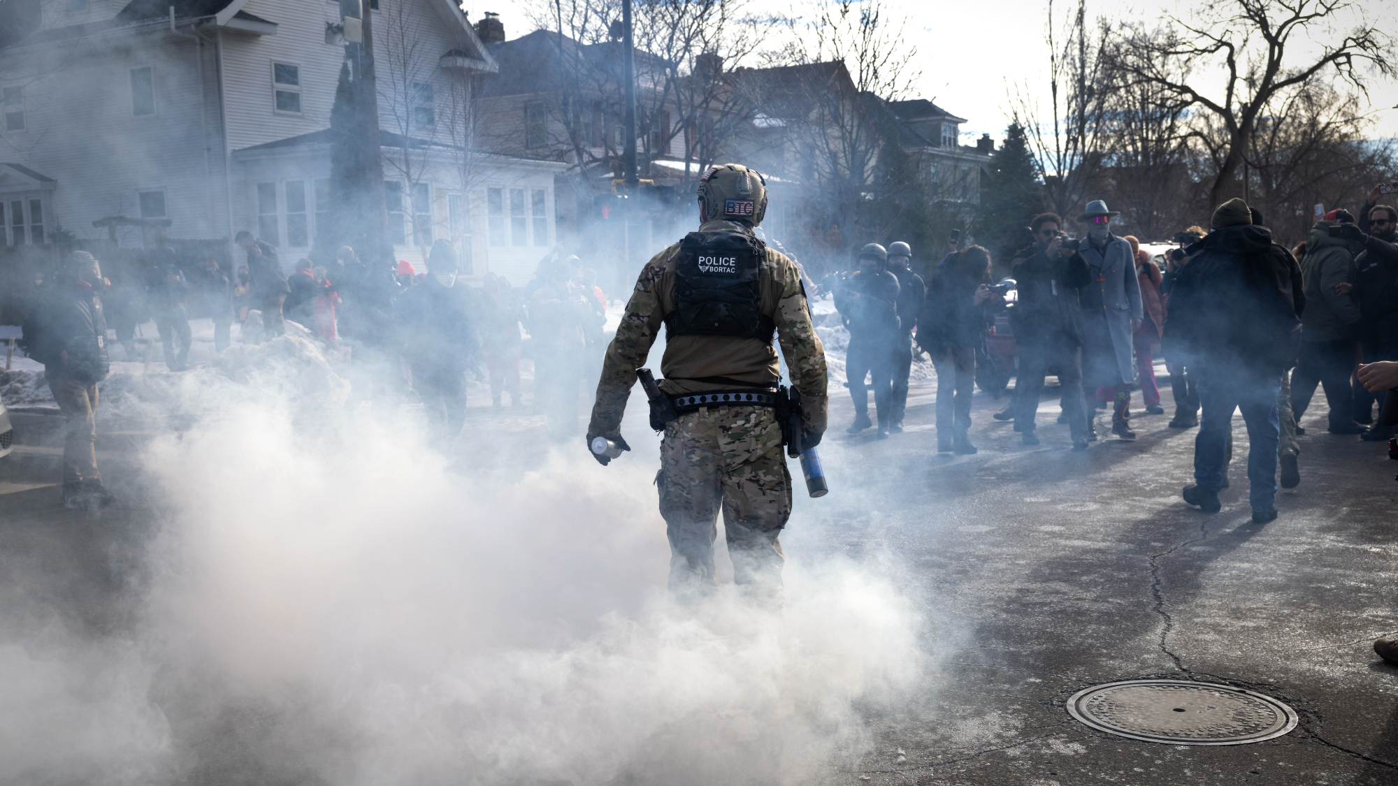 ICE agents stands off against protesters in Minneapolis with gas cannister in hand