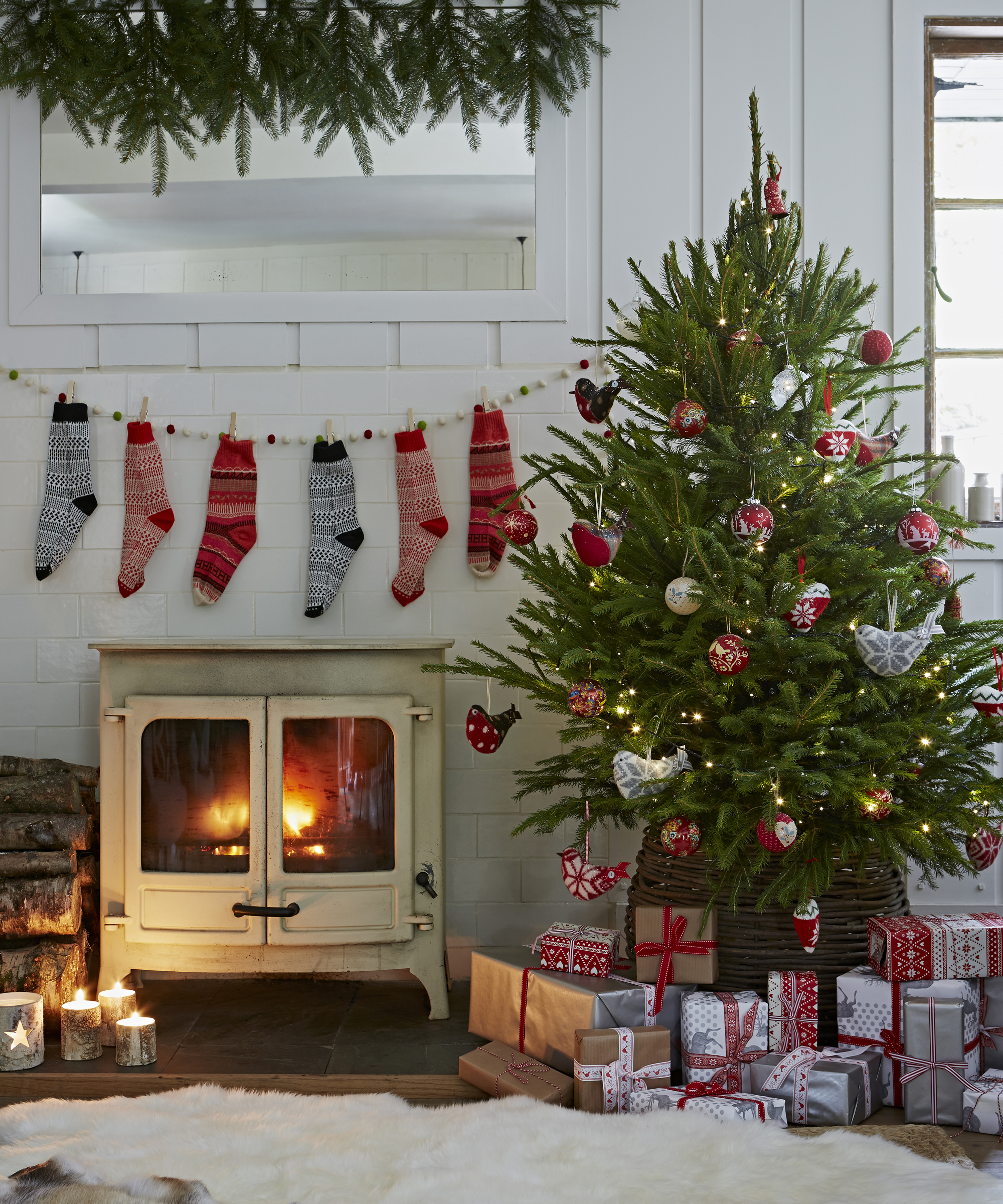 Christmas tree ideas with Scandinavian style red and white fabric decorations, in a white room next to the fire