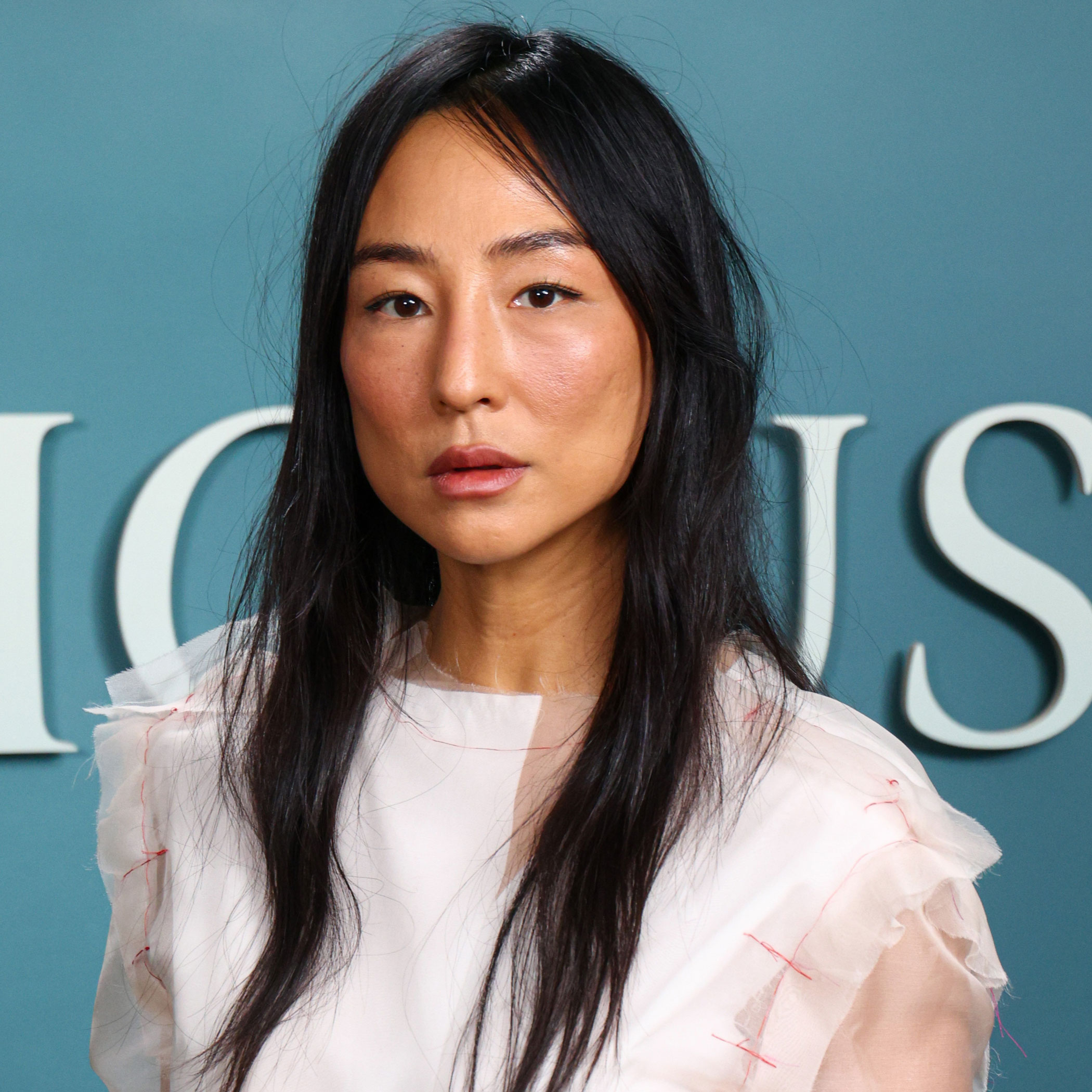Greta Lee wears a white shirt by The Row