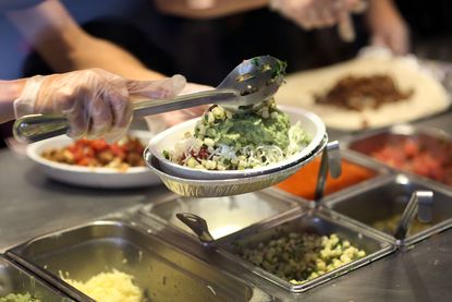 Chipotle workers create a meal for customers