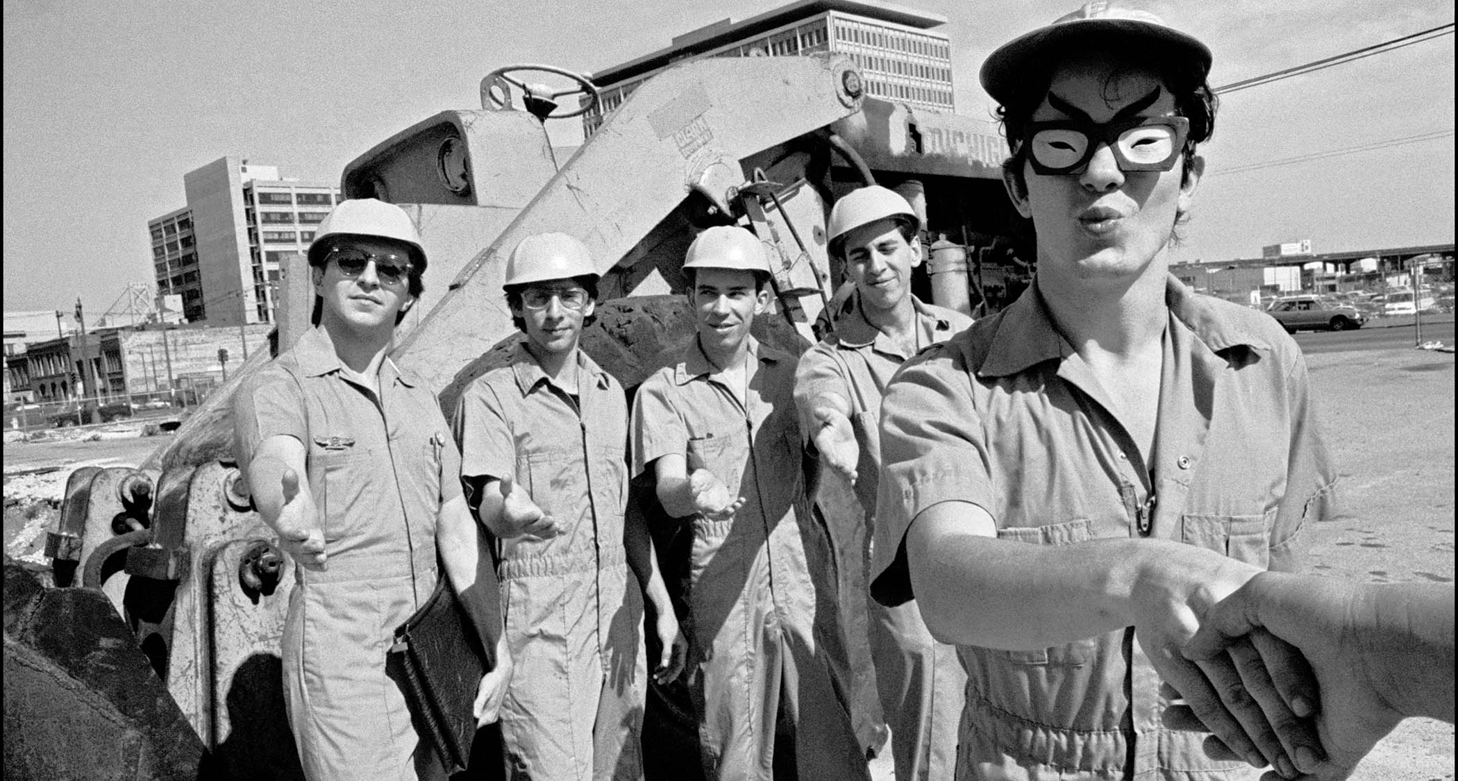 Devo pictured in boiler suits and hard hats, 1977
