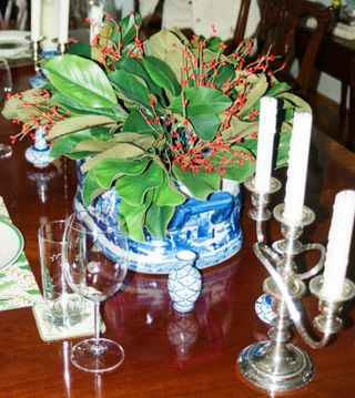 a Christmas table centrepiece of natural foliage with candelabras either side