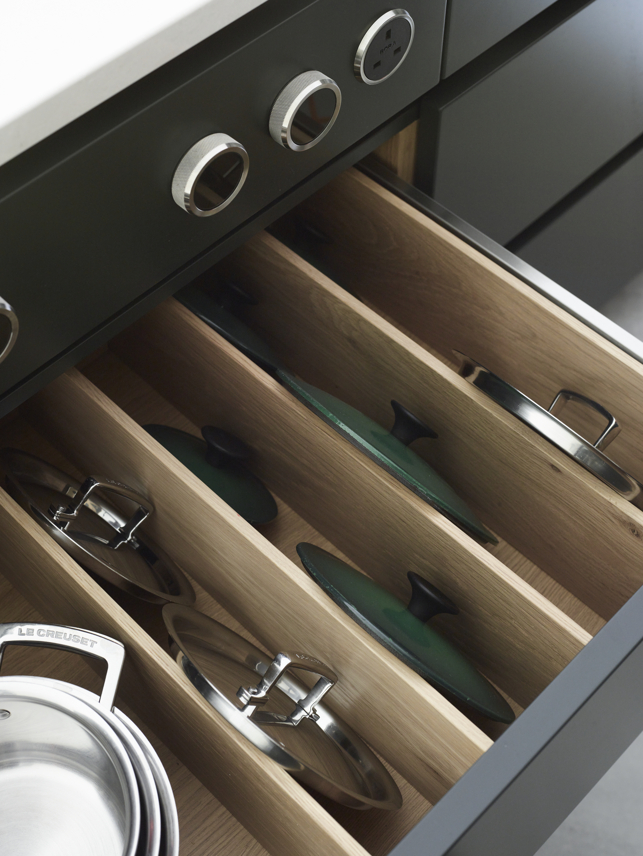 A kitchen island with a pull-out drawer with a socket above it