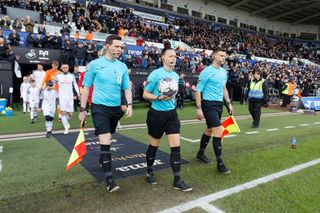 Referee Rebecca Welch (C) and her assistants lead the two teams onto the pitch prior to the Sky Bet Championship match between Swansea City and Blackburn Rovers at the Swansea.com Stadium on March 02, 2024 in Swansea, Wales.