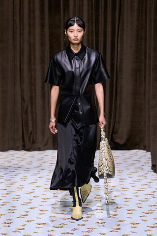 Uma Modelo Usa Um Acessório Com Estampa De Cobra Na Passarela Da Jil Sander.