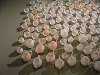 White teapots and cups on a concrete floor