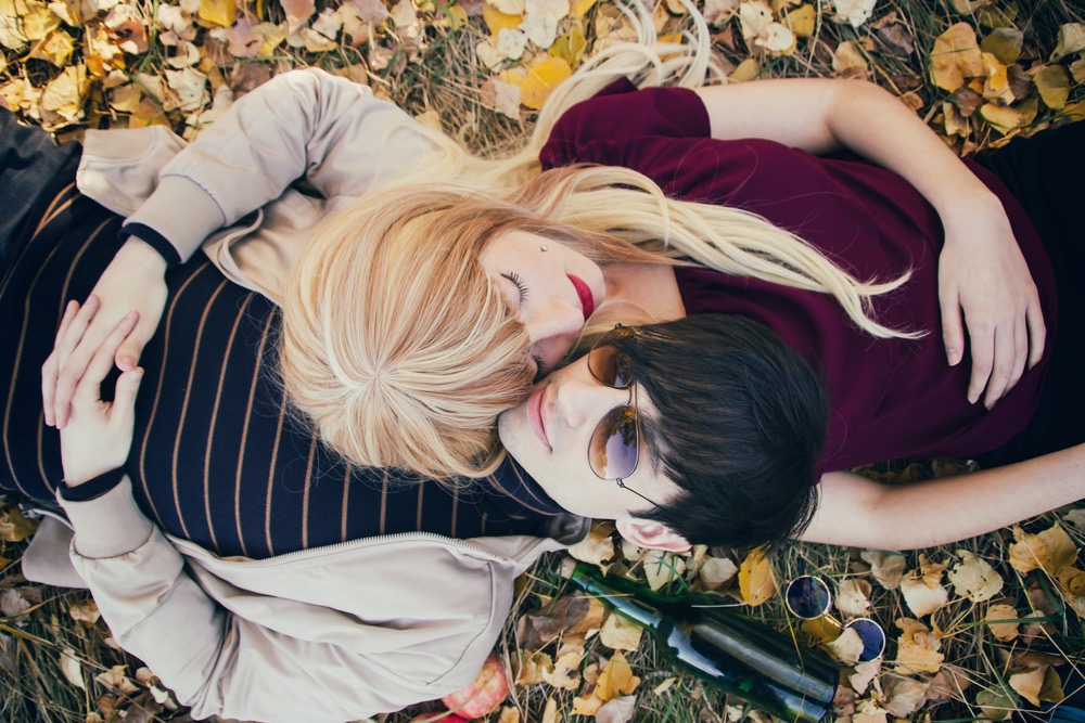 Young couple lying together in a park in autumn.