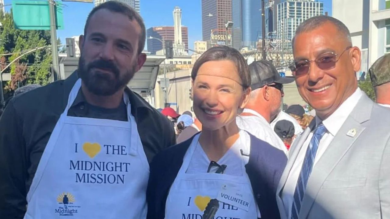 Ben Affleck and Jennifer Garner wearing white aprons and smiling with a man