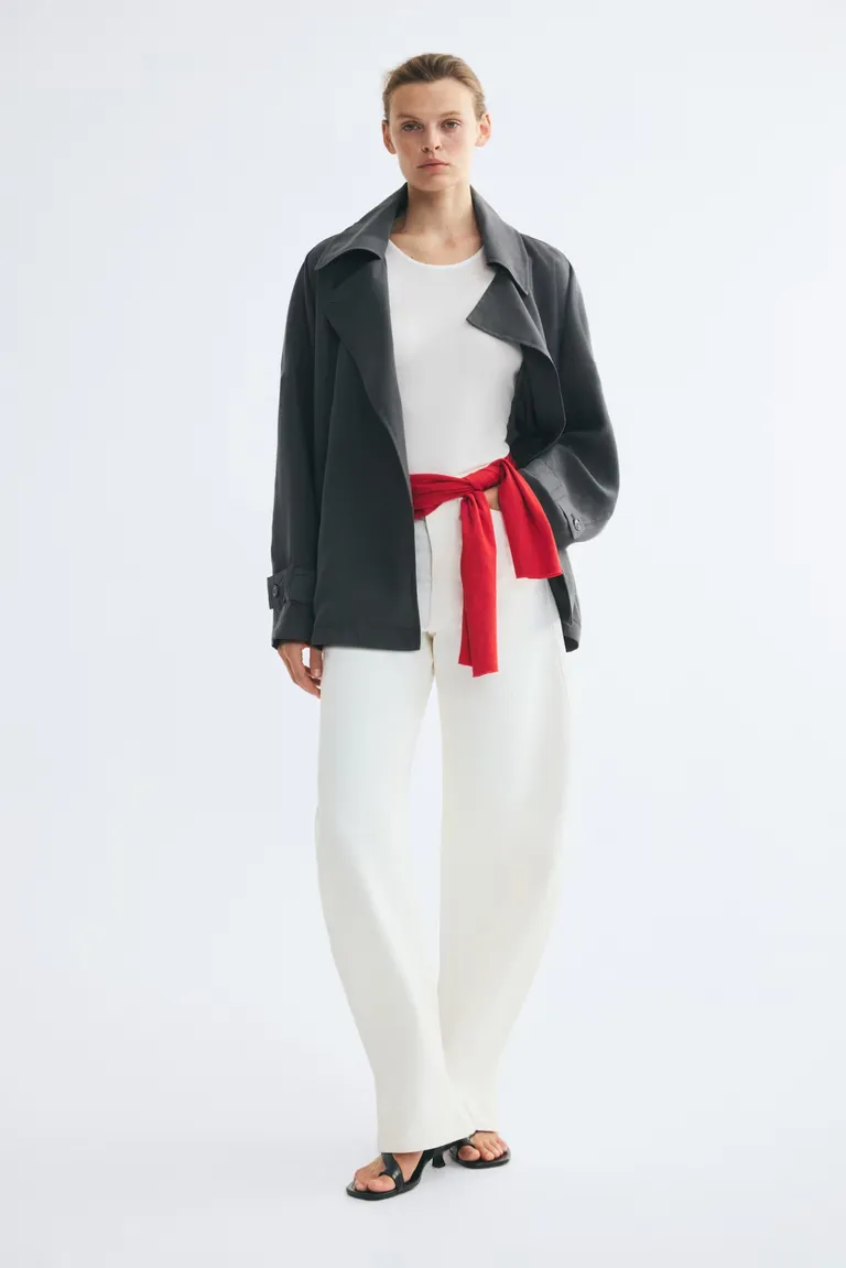 Model wears slate grey jacket, white top, red cardigan, white jeans and black heels