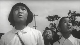 Women watch as a plane flies overhead in Hiroshima