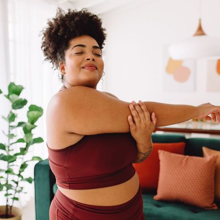 A woman strength training at home without equipment 