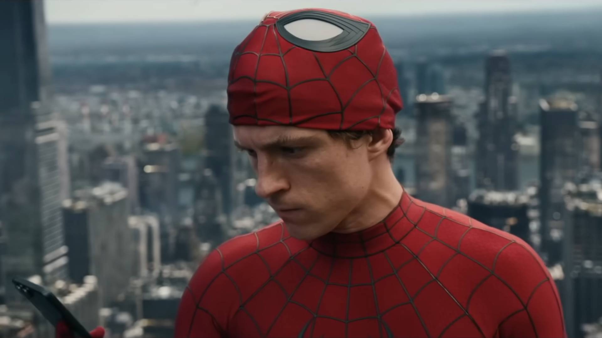 Tom Holland as Spider-Man looking at a phone in Spider-Man: Brand New Day