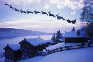 Santa's sleigh being pulled by nine reindeer over a snowy field