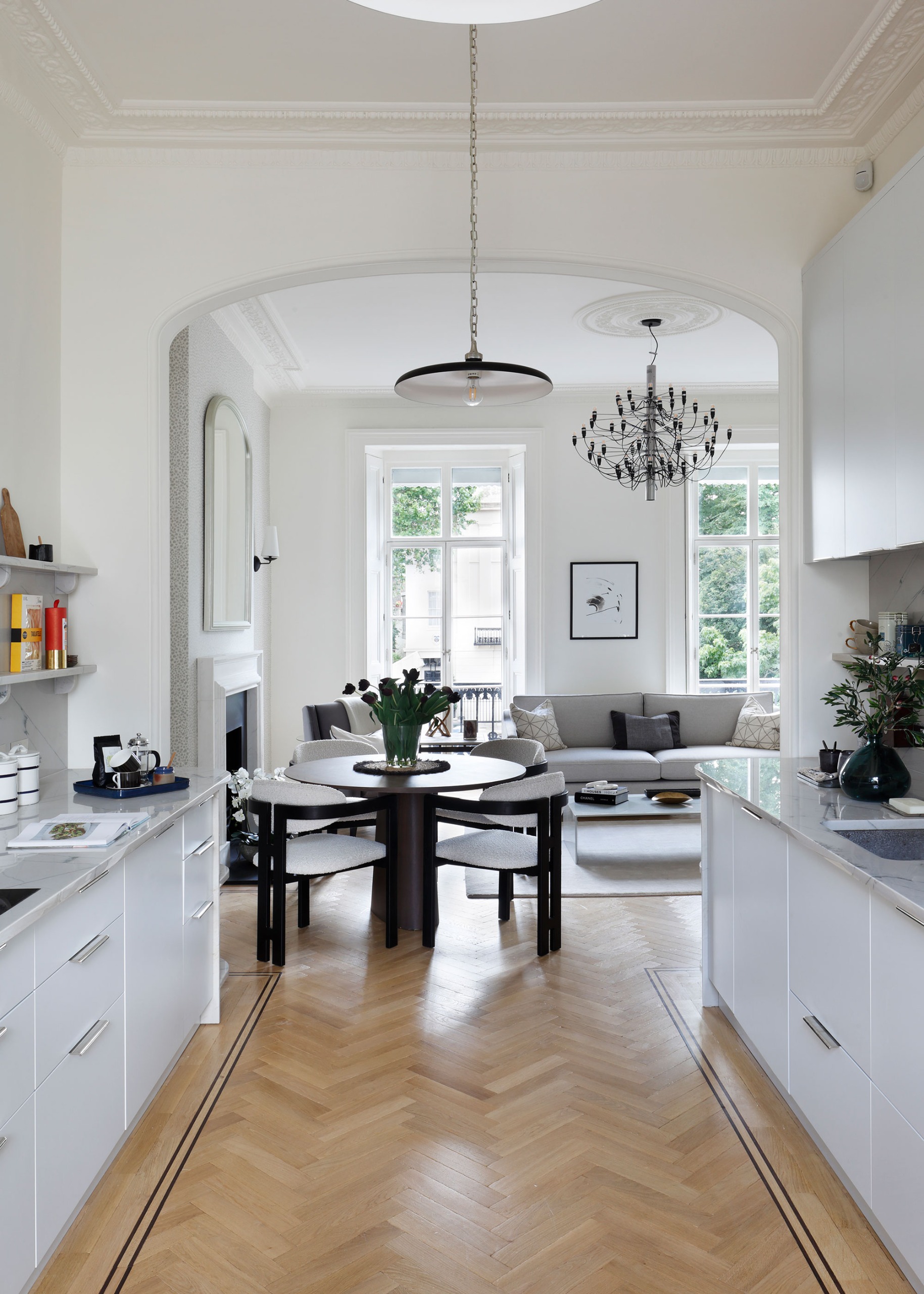 townhouse white kitchen leading to open dining and living area through archway