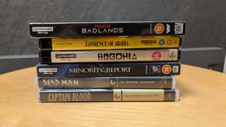 4K Blu-ray collection hero image with Minority Report, Lawrence of Arabia, Bugonia, Predator: Badlands, Dead Man and Captain Blood 4K Blu-ray cases in a pile 