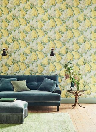 yellow floral wallpaper in living room with green sofa