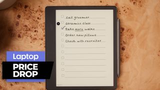 Kindle Scribe eReader with pen on wooden table with note on display