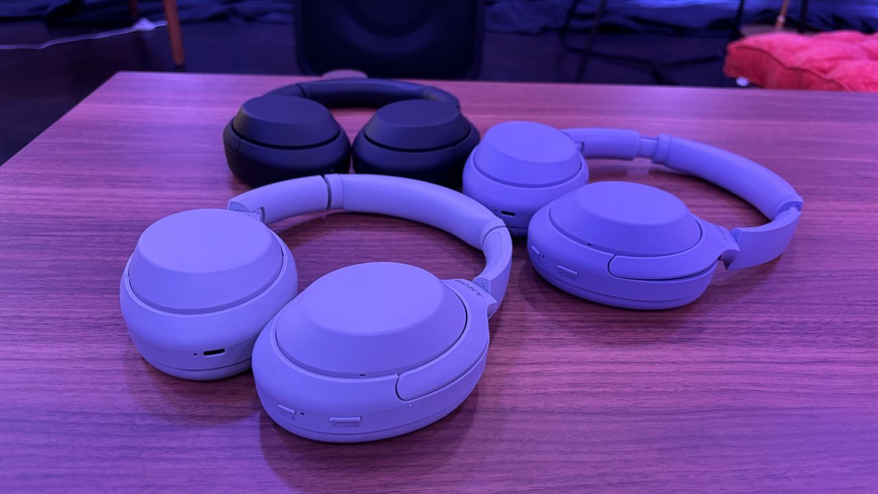Three pairs of Sony WH-1000XM4C wireless headphones arranged on a table